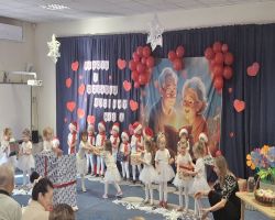 dzieci występują na scenie, pozują do zdjęć z dziadkami