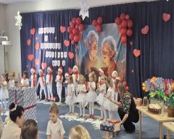 dzieci występują na scenie, pozują do zdjęć z dziadkami