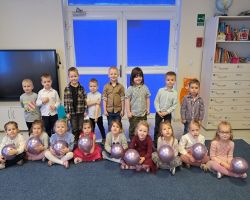 dzieci świętują Dzień Kobiet i Dziewczynek chłopcy składają życzenia i wręczają kwiaty