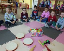 dzieci wykonujące prace plastyczne oraz grające na instrumentach perkusyjnych