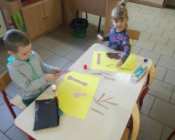 dzieci wykonujące prace plastyczne oraz grające na instrumentach perkusyjnych