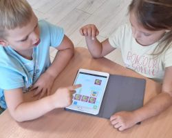 Dzieci pracują na tabletach i macie do kodowania