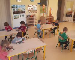 dzieci wykonujące zadania na tabletach