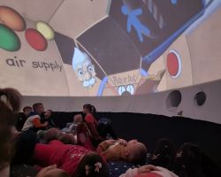 zdjęcia dzieci podczas seansu w mobilnym planetarium