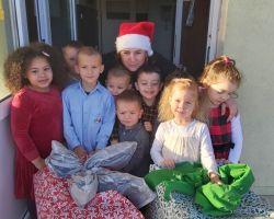 dzieci rozpakowujące preznety bożonarodzeniowe