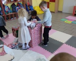 dzieci rozpakowujące preznety bożonarodzeniowe